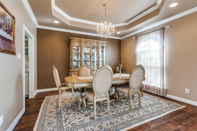 dining space with a tray ceiling, a chandelier, and ornamental molding