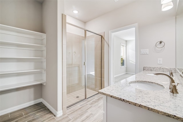 bathroom with double vanity and a shower with shower door