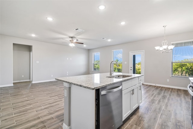 kitchen with white cabinets, hanging light fixtures, a kitchen island with sink, dishwasher, and sink