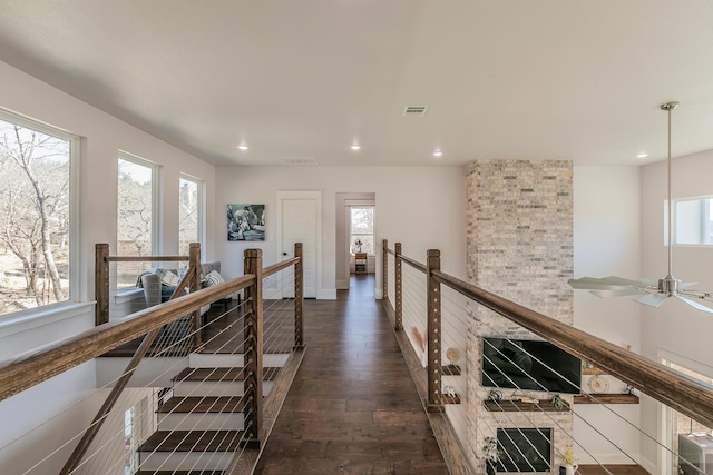 hall featuring a wealth of natural light and dark wood-type flooring