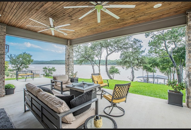 view of patio featuring an outdoor living space with a fire pit, ceiling fan, and a water view