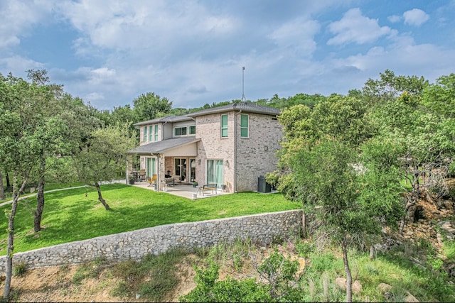 back of property with a yard and a patio