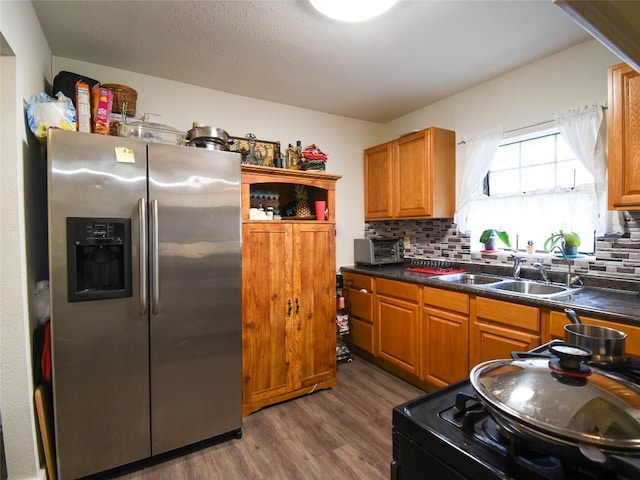 kitchen featuring range, backsplash, dark hardwood / wood-style floors, stainless steel fridge with ice dispenser, and sink