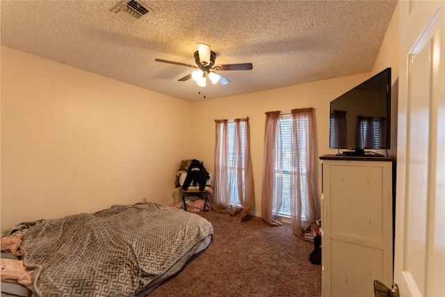 carpeted bedroom with ceiling fan and a textured ceiling