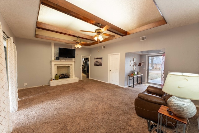 unfurnished living room featuring carpet, ceiling fan, a raised ceiling, and a fireplace