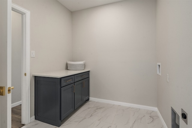 clothes washing area with cabinets, hookup for a washing machine, and light tile patterned floors