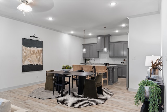 dining space with crown molding, ceiling fan, and light hardwood / wood-style flooring