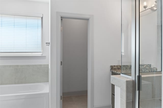 bathroom featuring vanity, a bathtub, and tile patterned floors