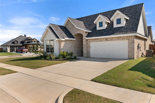 view of front of home featuring cooling unit, a garage, and a front yard