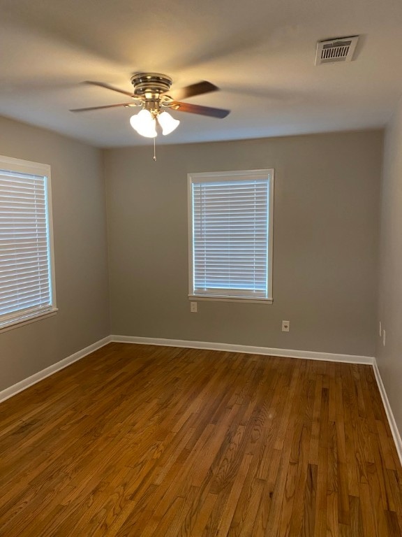 empty room featuring ceiling fan and dark hardwood / wood-style flooring