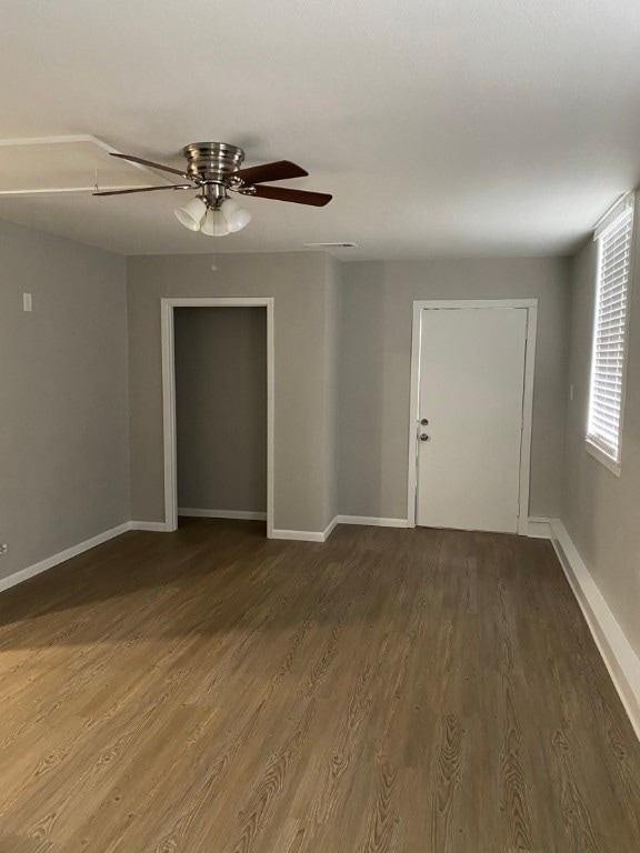 empty room featuring ceiling fan and dark wood-type flooring