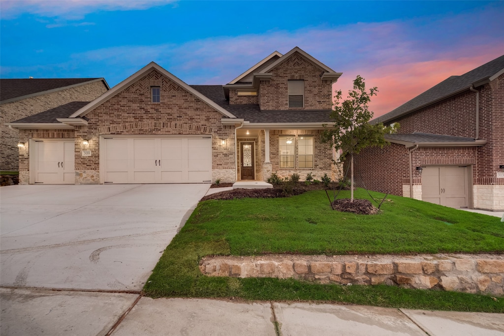 view of front of property featuring a lawn and a garage