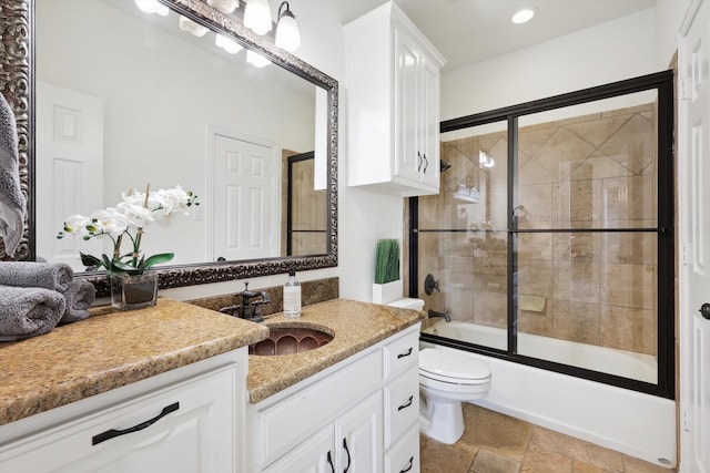 full bathroom with vanity, toilet, and bath / shower combo with glass door