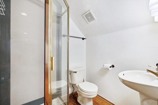 bathroom with toilet, hardwood / wood-style floors, sink, lofted ceiling, and a shower with shower door