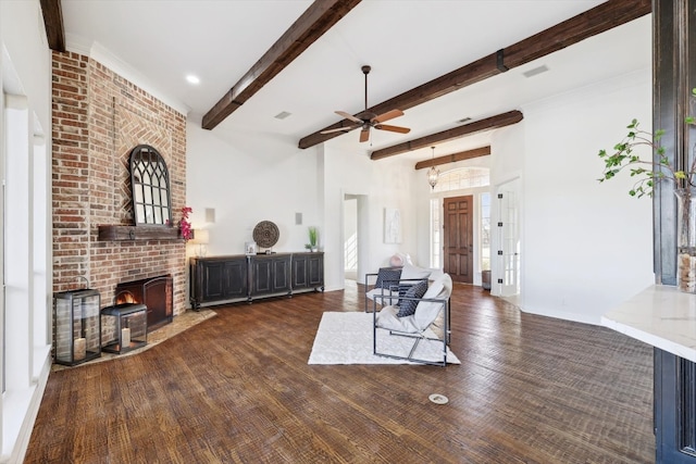 living room featuring ceiling fan, dark hardwood / wood-style floors, beam ceiling, and a fireplace