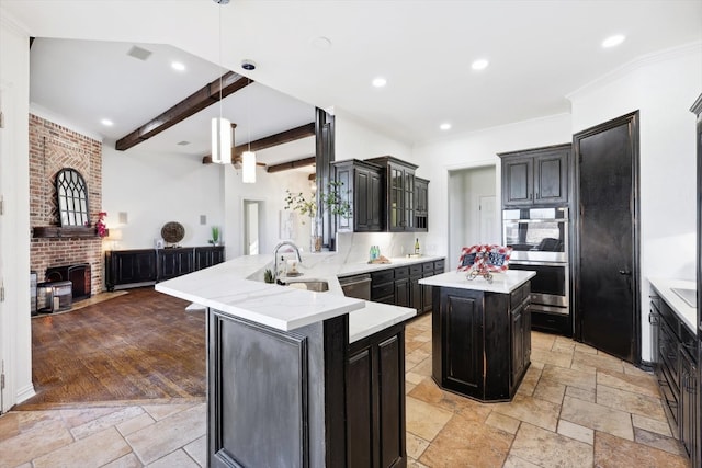 kitchen with light wood-type flooring, beamed ceiling, kitchen peninsula, pendant lighting, and a kitchen island