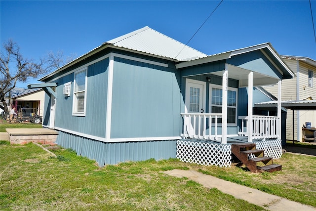 view of side of home featuring a lawn and a porch