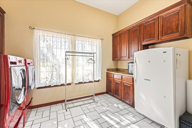 kitchen with white fridge, light tile floors, and a healthy amount of sunlight