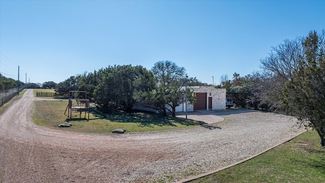 view of front of property with a garage, a front lawn, and a playground