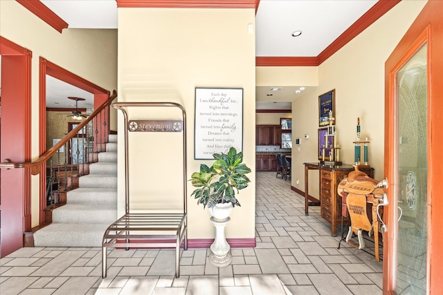 tiled foyer entrance featuring ceiling fan and crown molding