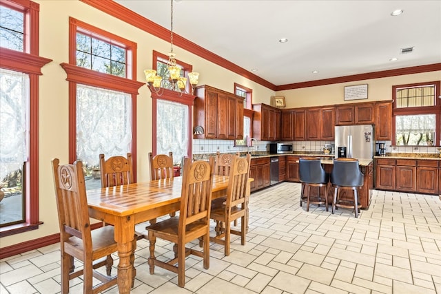 dining room with crown molding, a chandelier, and plenty of natural light