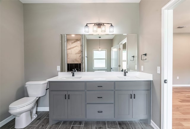 full bathroom featuring baseboards, a sink, toilet, and wood tiled floor