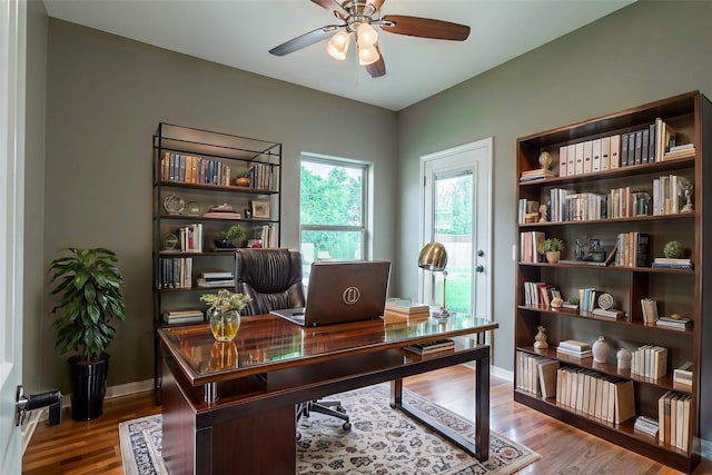 home office with baseboards, a ceiling fan, and wood finished floors