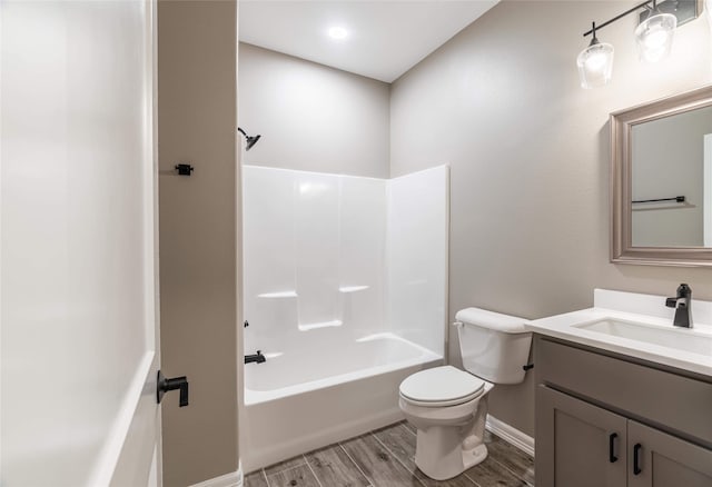 bathroom featuring tub / shower combination, vanity, toilet, and wood finished floors