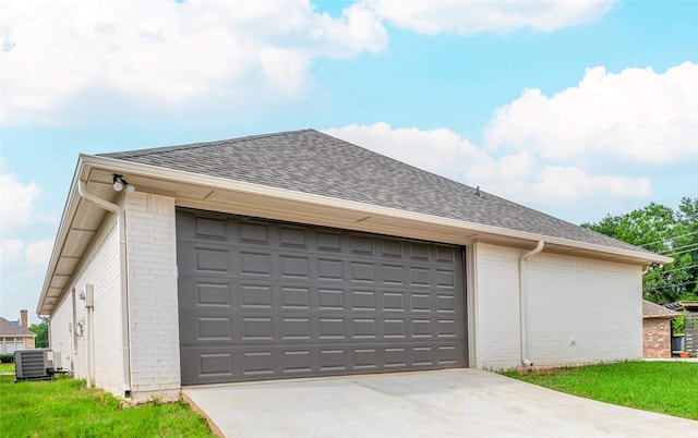 garage featuring concrete driveway and central air condition unit