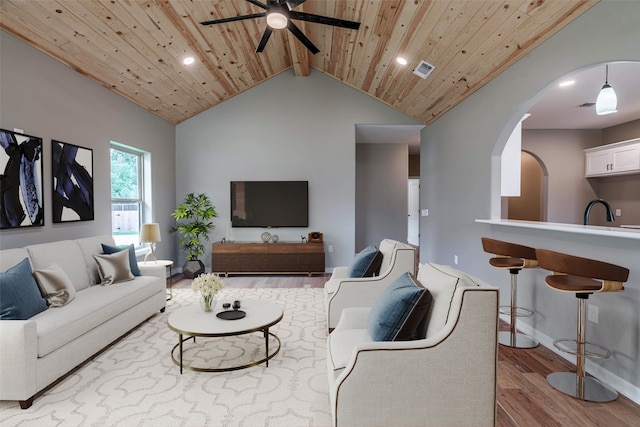 living room featuring sink, ceiling fan, beam ceiling, light hardwood / wood-style floors, and wood ceiling