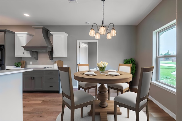 dining space featuring baseboards, recessed lighting, a chandelier, and light wood-style floors