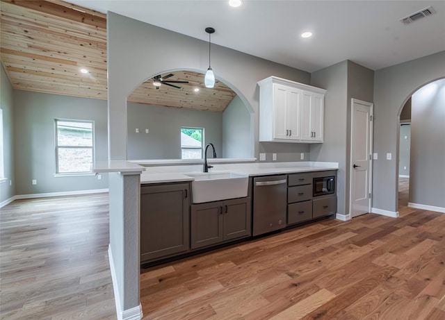 kitchen featuring visible vents, arched walkways, dishwasher, light countertops, and a sink