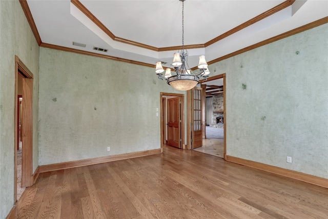 unfurnished room featuring a notable chandelier, crown molding, and light hardwood / wood-style flooring