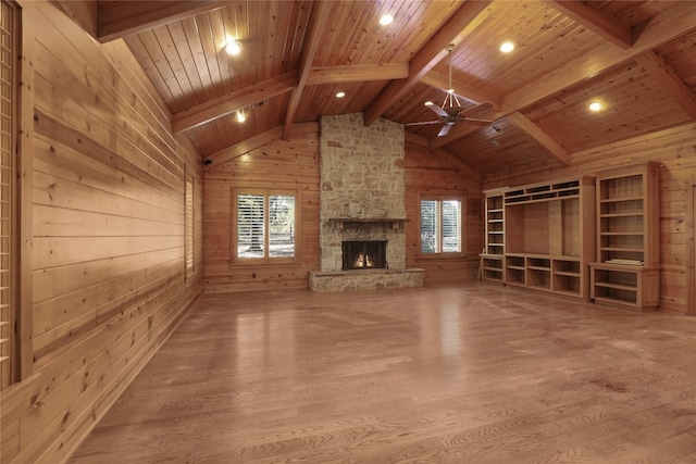 unfurnished living room with wooden walls, wood ceiling, hardwood / wood-style flooring, and a fireplace