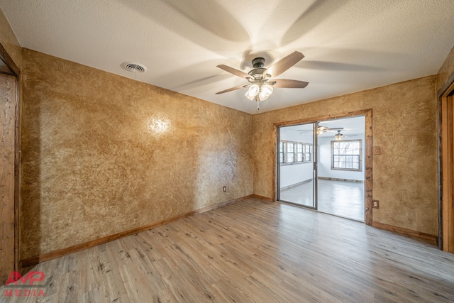 unfurnished room featuring ceiling fan, a textured ceiling, and light wood-type flooring