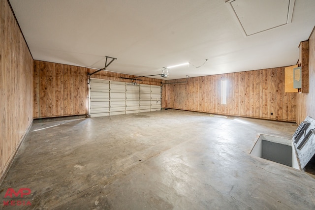 garage featuring a garage door opener and wood walls