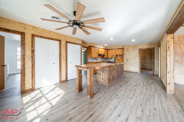 kitchen featuring ceiling fan, light hardwood / wood-style floors, sink, and butcher block countertops