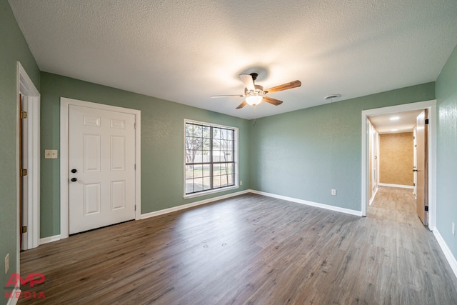 interior space featuring hardwood / wood-style floors, a textured ceiling, and ceiling fan