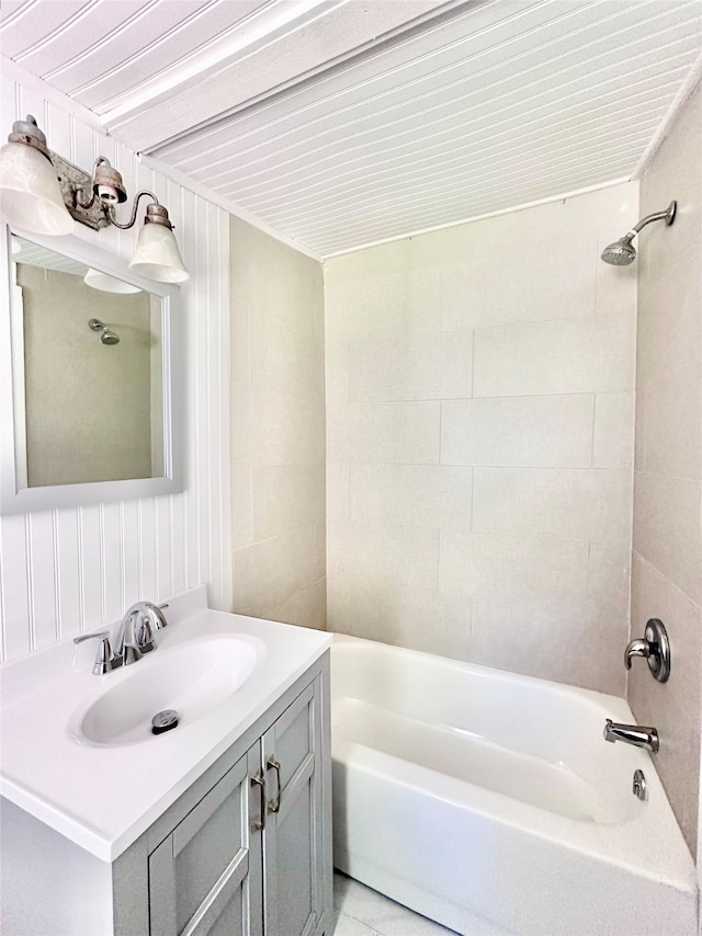 bathroom with tiled shower / bath combo and vanity with extensive cabinet space