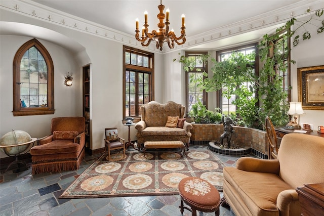 living area featuring a notable chandelier, dark tile flooring, and crown molding