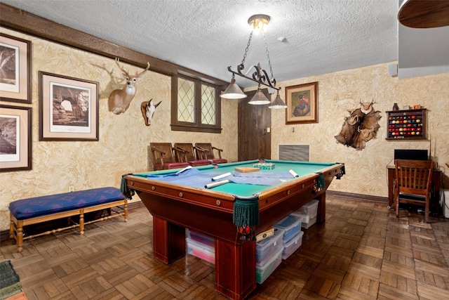 playroom with a textured ceiling, pool table, and dark parquet flooring