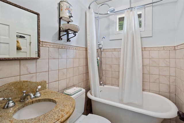 full bathroom with shower / bath combo with shower curtain, tile walls, toilet, and sink