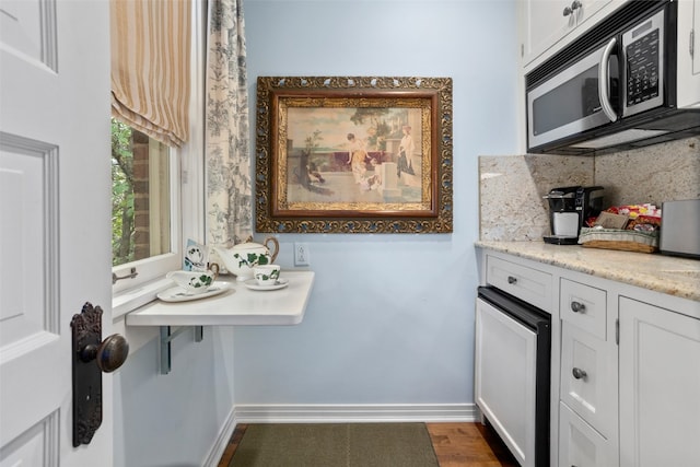 kitchen featuring light stone countertops, white cabinetry, and dark wood-type flooring