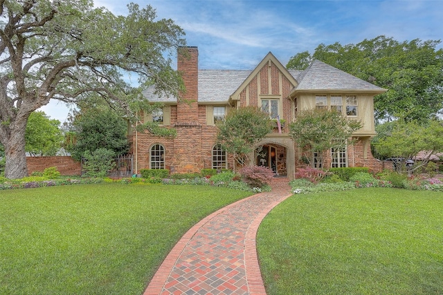 english style home featuring a front yard