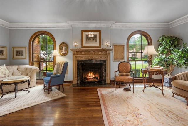 sitting room featuring crown molding, dark wood-type flooring, and a fireplace