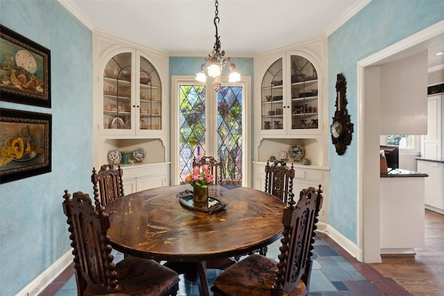 dining space with dark hardwood / wood-style flooring, a notable chandelier, crown molding, and built in features