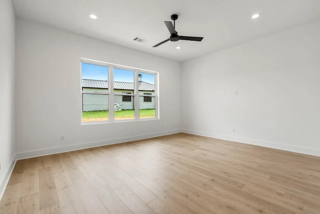 empty room with ceiling fan and light hardwood / wood-style flooring