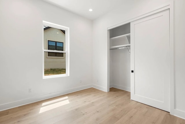 unfurnished bedroom featuring light hardwood / wood-style floors and a closet