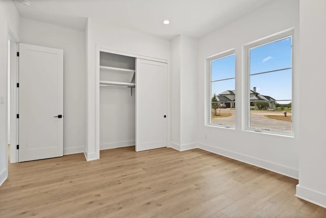 unfurnished bedroom featuring light hardwood / wood-style floors and a closet