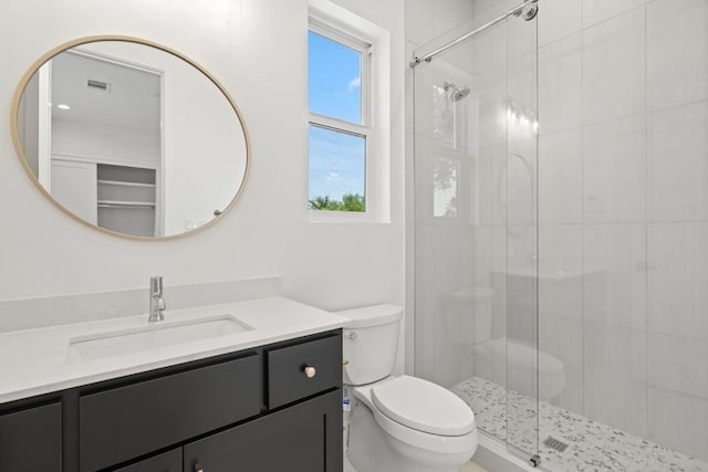 bathroom featuring an enclosed shower, toilet, and vanity with extensive cabinet space